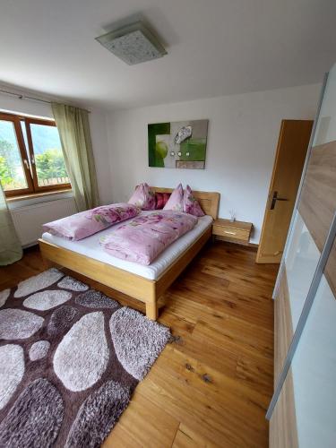 1 dormitorio con cama con sábanas rosas y alfombra en Ferienwohnung Julia Kröll, en Mittersill