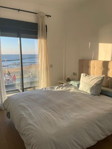 1 dormitorio con 1 cama y vistas a la playa en Apartamento con piscina en el Paseo Cruz del Mar, en Chipiona
