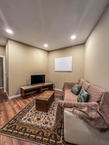 a living room with a couch and a flat screen tv at Comfort Tua in Mirandela
