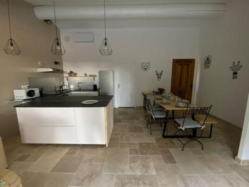 a kitchen and dining room with a table and a counter at Maison au calme au pied du luberon in La Bastide-des-Jourdans