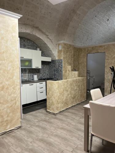 a kitchen with white cabinets and a brick wall at JASMINE HOUSE in Triggiano