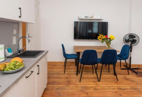 a kitchen with a wooden table and blue chairs at PROVENIR HOME KWIATOWA 5 in Poznań