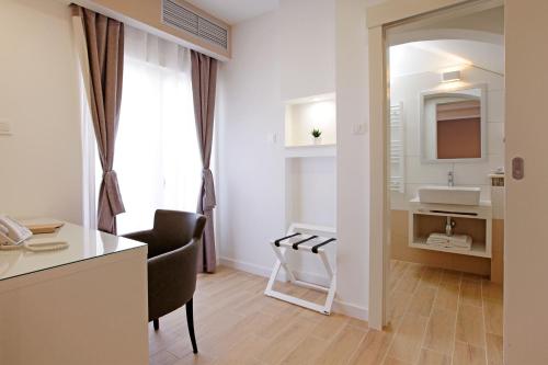 a bathroom with a desk and a sink in a room at Hotel Villa Telenta in Vela Luka