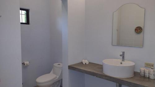 a white bathroom with a sink and a toilet at Casa Todo Bueno in Transito