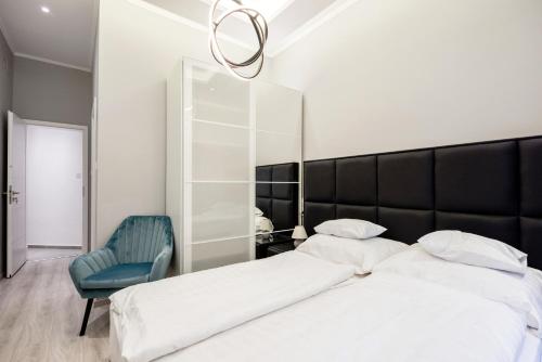 a bedroom with a large bed and a blue chair at A Golden Star Modern Luxury Apartments and Rooms Budapest in Budapest