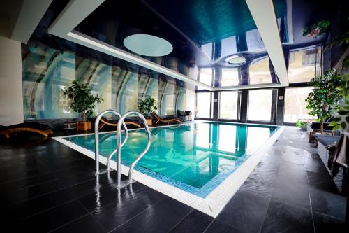 a large swimming pool with two metal swimmers in a building at Jonathan Spa Estate in Amatciems