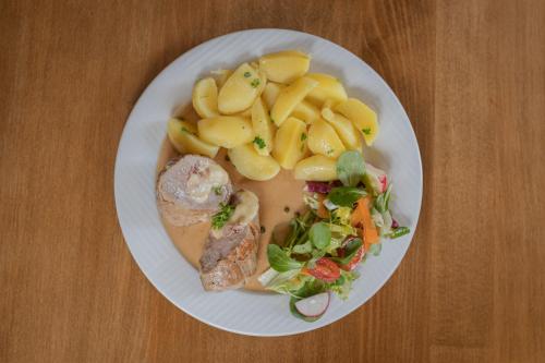 a plate of food with pasta and a salad at Restaurant & Pension Liebenstein in Libá