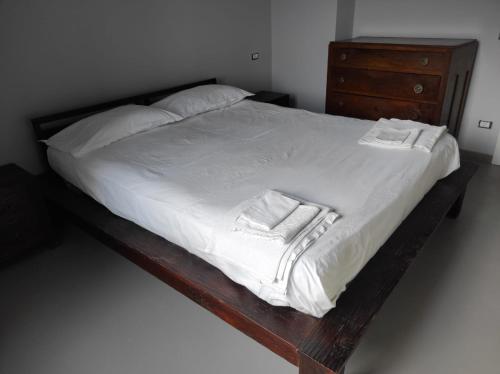 uma cama com lençóis brancos e toalhas em Fantastica casa ai piedi del Monte Pollino em San Lorenzo Bellizzi