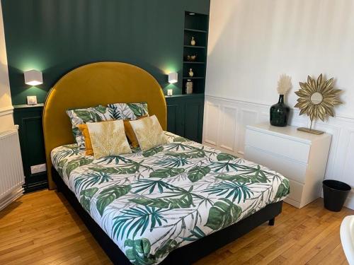 a bedroom with a bed with a wooden headboard at L'AMAZONIE - Lovely apartment near to the train station and Orly Airport in Juvisy-sur-Orge