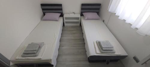 two twin beds in a room with a staircase at Urban House M & M in Mostar
