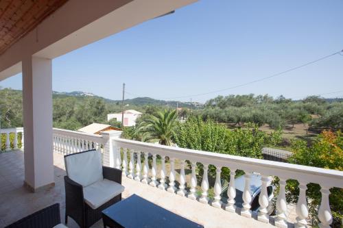 a balcony of a house with a chair and a view at Villa Marinos & Pool in Petrití