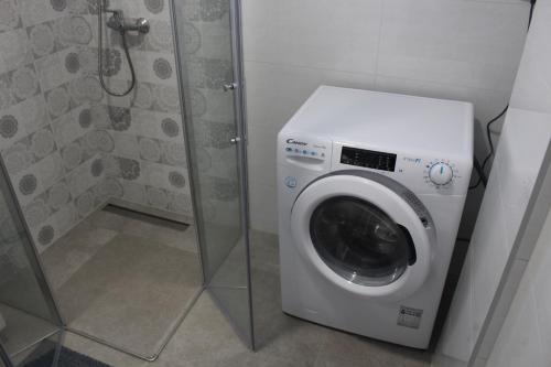 a washing machine in a bathroom with a shower at Apartman Srna Pale in Pale