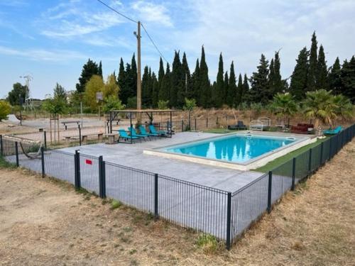 uma piscina com uma cerca à volta em La Massoterie gîte 3 em Théza