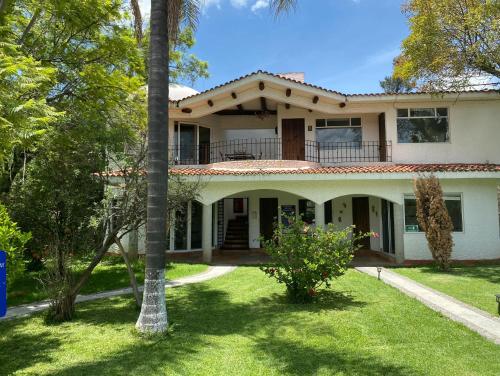 una casa con una palmera delante de ella en Villa Coiros Bici, Hospedaje y Bienestar, en Tonatico