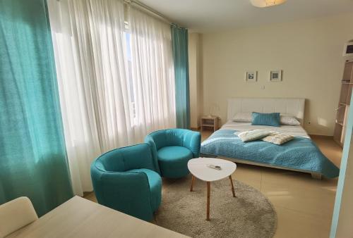 a bedroom with a bed and a chair and a table at Cuvi Studio S in Rovinj