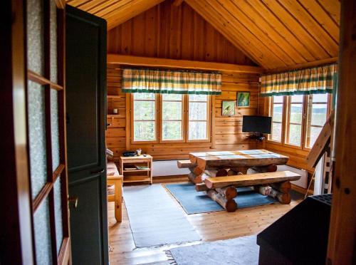 a living room with a table in a log cabin at Tunturilapin Tuvat in Muonio