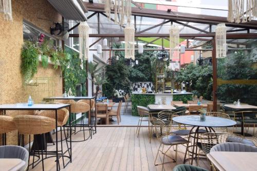 an empty restaurant with tables and chairs and plants at John's Hotel in Chalkida