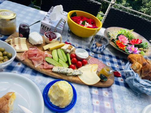 a picnic table with cheese and other foods on it at Cozy room with a beautiful garden view in Baunatal