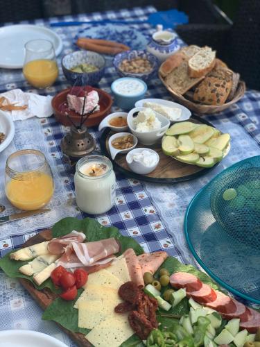 a table with many plates of food on it at Cozy room with a beautiful garden view in Baunatal