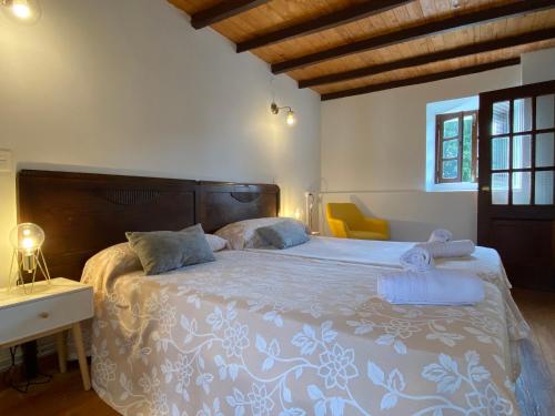 a bedroom with a large bed with a wooden headboard at La Reserva de Los Campos in Cadavedo