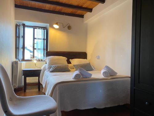 a bedroom with a bed with a chair and a desk at La Reserva de Los Campos in Cadavedo