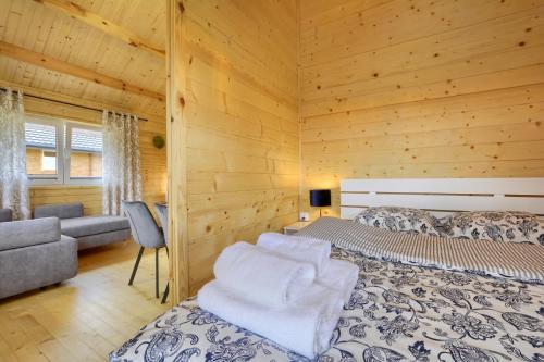 1 dormitorio con 2 camas en una cabaña de madera en Domki Pod Sudeckim Niebem, en Duszniki-Zdrój