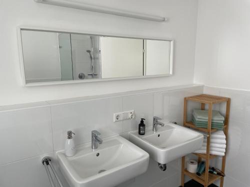 Baño blanco con 2 lavabos y espejo en Skyblue, en Friedrichshafen