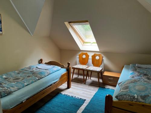 - une chambre mansardée avec 2 lits et une fenêtre dans l'établissement Palma Apartment 2, à Schottwien