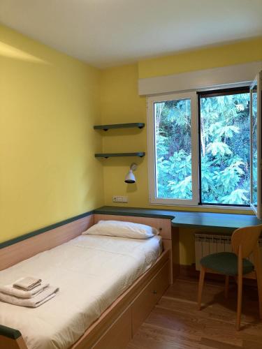 a small bedroom with a bed and a window at Juan Belmonte ONGI ETORRI in Zumaia