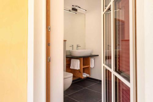 a bathroom with a sink and a toilet and a mirror at Hotel Garni zum Schwan in Waldmünchen