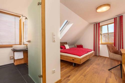 a bedroom with a bed with a red blanket at Hotel Garni zum Schwan in Waldmünchen