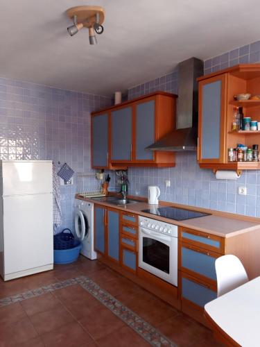 a kitchen with brown cabinets and a white refrigerator at Juan Belmonte ONGI ETORRI in Zumaia