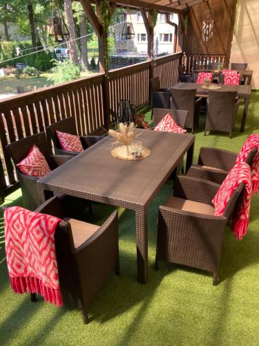 a wooden table and chairs with blankets on them at Hotel Bella in Jelenia Góra