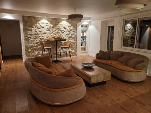 a living room with two couches and a table at Hôtel Restaurant Le Lachens in La Bastide