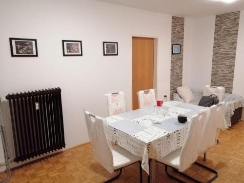 una sala da pranzo con tavolo e sedie bianchi di Arena stožice rooms a Lubiana