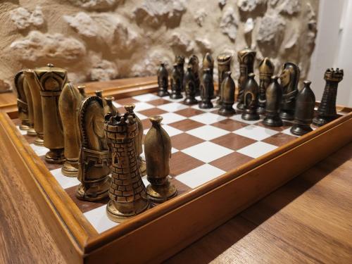 um tabuleiro de xadrez está alinhado numa mesa em Hôtel Restaurant Le Lachens em La Bastide