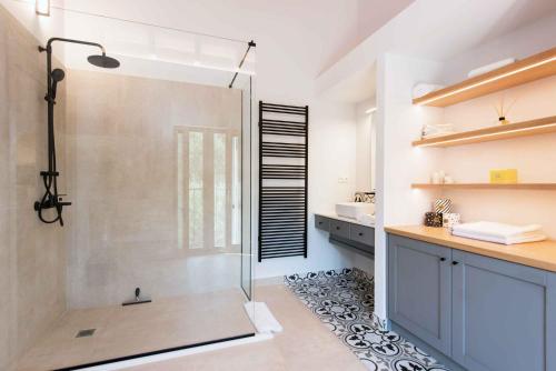 a bathroom with a shower with a glass door at Villa Helonaki in Kassiopi