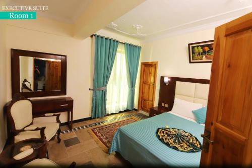 a bedroom with a bed and a desk and a mirror at Canari Hotel kashmir view in Nathia Gali