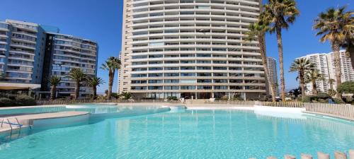 a large swimming pool in front of a tall building at VIVE LA EXPERIENCIA, PLAYA, SPA, CASINO DE JUEGOS in Coquimbo