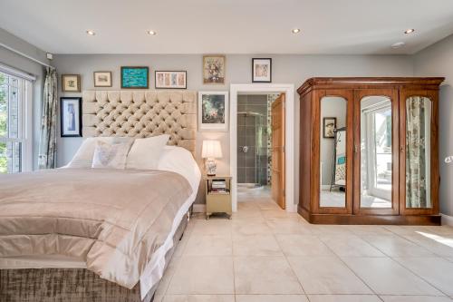 a bedroom with a large bed and a wall of windows at Clonaslee House in Coleraine