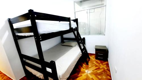 a black bunk bed in a room with a window at Departamento en Pacasmayo in Pacasmayo