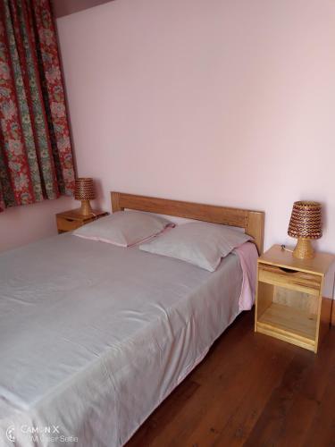 a bedroom with a bed and a table with a lamp at Le Manoir in Antananarivo