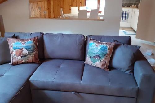 a blue couch with two pillows on it at Casa vacanze Portigliatti: Elegante mansarda... in Cogne