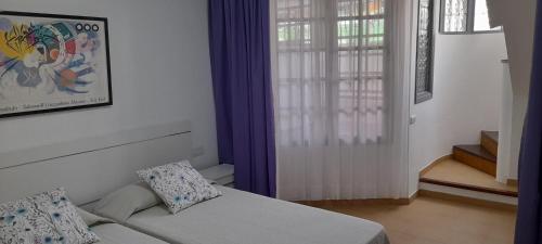 Cette petite chambre comprend un lit et une fenêtre. dans l'établissement APARTAMENTO EN CORRALEJO, à Corralejo