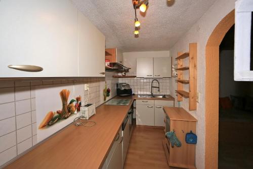 eine Küche mit weißen Schränken und einer hölzernen Arbeitsplatte in der Unterkunft Kuanerhof Wohnung 2-4 Personen in Ried im Zillertal