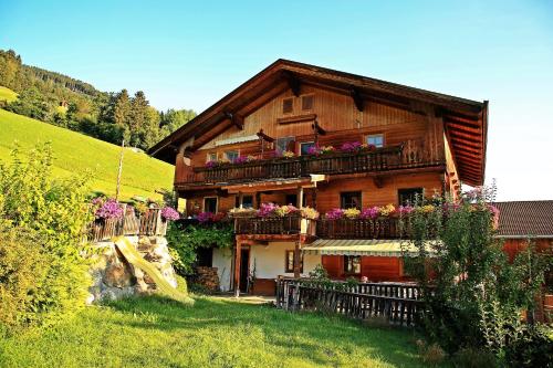 ein Haus mit Blumen auf den Balkonen und einer Rutsche in der Unterkunft Kuanerhof Wohnung 2-4 Personen in Ried im Zillertal