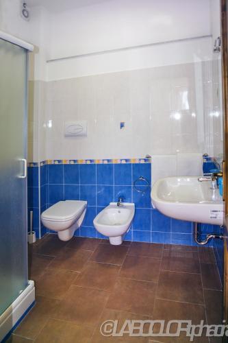 a bathroom with two sinks and a tub and a toilet at Residence Villa Mare Taormina in Letojanni