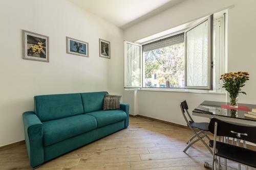 ein Wohnzimmer mit einem grünen Sofa und einem Tisch in der Unterkunft CityLife, Fiera City, MiCo & San Siro Apartment in Mailand