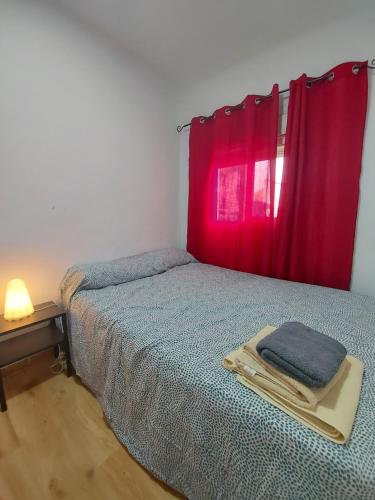 een slaapkamer met een bed en een rood raam bij Madrid Apartament in Madrid