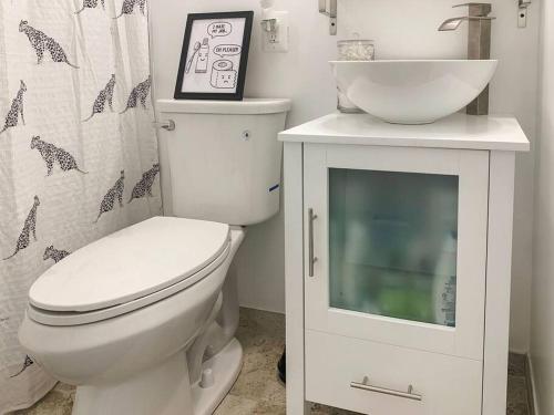 a bathroom with a white toilet and a sink at Cozy Modern Apt in the Heart of Fells Point! in Baltimore